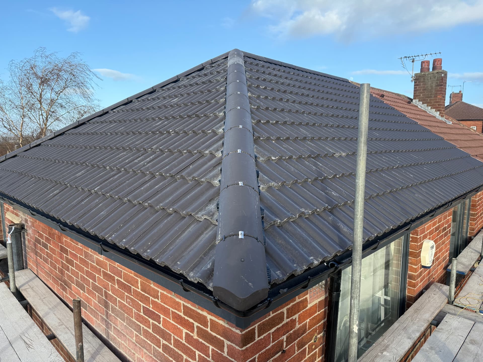 Newly tiled hipped roof on a brick extension